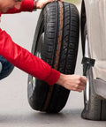 Man installing Spare Tire Hold Down Bolt Retainer Clamp For Cars And Trucks, Stays Put On Rough Roads And Keeps Spare Quiet