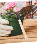 Long Handled Manganese Steel Multi Functional Sickle For Weeding And Harvesting With Ergonomic No Sweat Grip next to potted plant