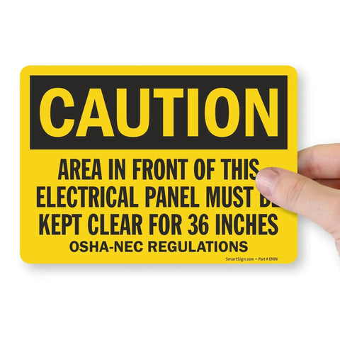 4 Pack OSHA Warning Stickers For Area In Front Of Electrical Panel Must Be Kept Clear For 36 Inches, yellow caution sticker held by hand