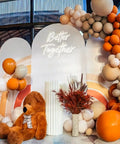 Event backdrop with 'Better Together' neon sign, teddy bear, balloons, and decor