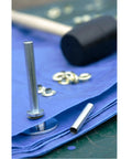 Close-up of Grommet Kit With Tools For Canvas And Leather Repairs 20 Piece Camping Grommets Set on blue fabric with tools visible