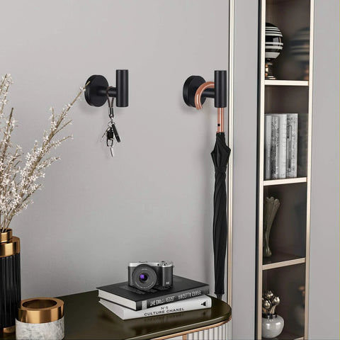 Four Pack Black Stainless Steel Towel Hooks Wall Mounted Heavy Duty Coat Robe Hanger For Door And Wall Use In Bathroom Bedroom Kitchen And Hotel Durable Waterproof Rustproof Modern Design Easy Drill Installation shown holding keys and umbrella