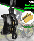 Black four-piston e-bike hydraulic disc brake caliper with pre-installed gold brake pads