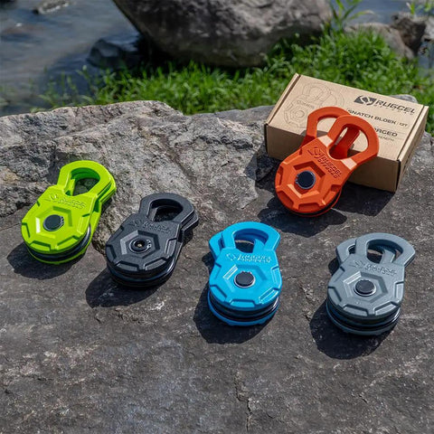 Snatch Block 12 Ton Heavy Duty Winch Pulley For Off Road Recovery in various colors on rocky outdoor surface