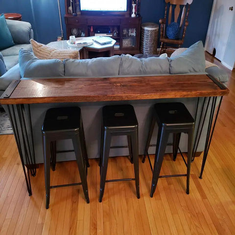 34 Inch Hairpin Table Legs Set For DIYers 1/2 Inch Dia 3 Rods Heavy Duty Metal Furniture Feet for Coffee Table TV Stand Mid Century Black with Floor Protectors 4 Pack in use on a wooden counter table behind stools.