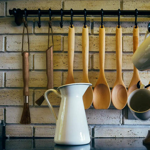 Barista Grade Coffee Grinder Cleaning Brush with natural boar bristles and walnut handle hanging on a kitchen rack.