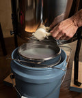 Stainless Steel Honey Strainer With Dual Sieve For Beekeeping filtering honey into a bucket