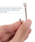 Thirty Pack Mini Iron Wall Hooks With Classic Silver Finish shown in hand, ideal for organizing coats and bags.