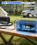 Heavy Duty 12V 50A LiFePO4 Battery Charger With 14.6V Boost connected to 12.8V battery on wood table outdoors