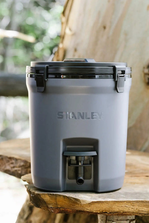 Adventure Fast Flow 2 Gallon Water Jug With Leakproof Ice Dispenser Easy Pour Spigot Latched Foam Lid on a wooden bench