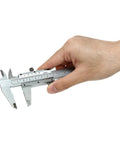 Hand holding Vernier Caliper 0-6 Inch / 0-150 Millimeters Manual Caliper Carbon Steel Pro Grade Built To Last With Knurled Thumb Roller