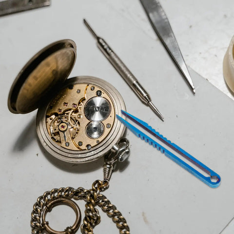 Titanium Alloy Tweezers Compact Machining Clamp Mini Travel Tool on workbench with watch and screwdriver visible