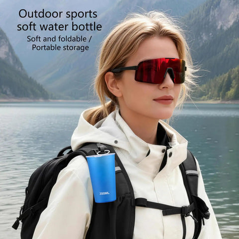 Person outdoors with backpack featuring Foldable Water Bottle 200ml Shatterproof, Lightweight Hydration Bottle For Running, Travel And Adventure.
