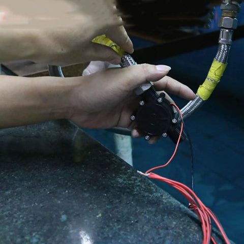 Hands installing Ultra Compact 10W Hydroelectric Generator Water Powered 12V DC Brushless Turbine With Voltage Stabilizer For DIY Projects