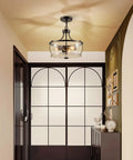 Firedanz 3-Light Glass Pendant Light, Height Adjustable in an entryway featuring clear glass shades and a black finish.