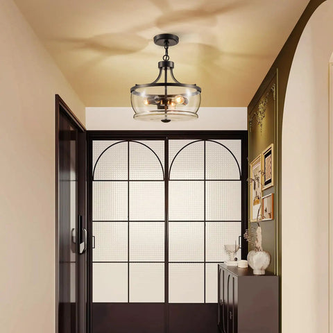 Firedanz 3-Light Glass Pendant Light, Height Adjustable in an entryway featuring clear glass shades and a black finish.