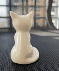 Sharp Ceramic Toilet Bolt Caps 2 Pack White Cat Design Decorative Screw Covers on a textured surface showcasing the back view.