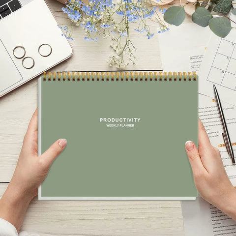Person holding Weekly Productivity Planner Notepad For Busy Pros, 8.5 By 11 Inch Dashboard Organizer With Six Focus Areas, Green cover.