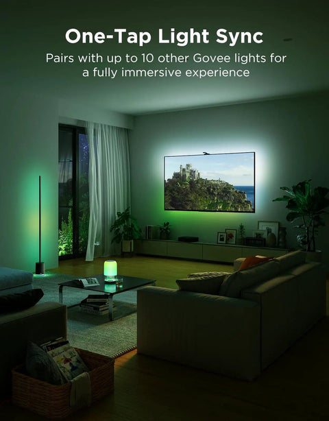 TV Backlight 3 Pro With HDR Triple Camera, Syncs To 75 85 Inch Screens, Ultra Clear HDR Image Capture For Brighter Highlights And Deeper Shadows, High Precision Triple Camera System, Perfect For An Immersive Movie Night And Gaming Setup. Green-lit living room with TV backlight and synced floor lamp.