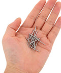 Hand holding stainless steel watch band pin replacement kit with quick release spring bars, 30 piece set for easy band swaps.