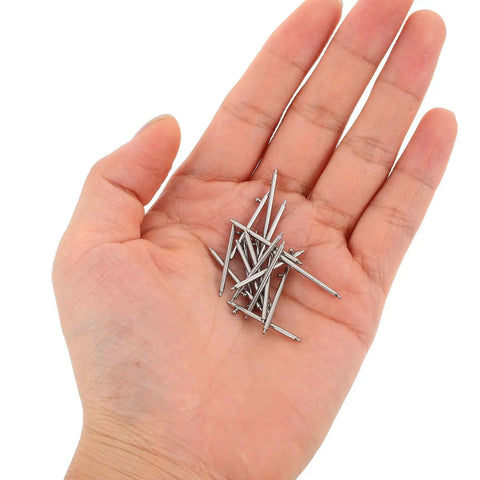 Hand holding stainless steel watch band pin replacement kit with quick release spring bars, 30 piece set for easy band swaps.