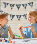 Girls painting snakes from Ten Piece Unfinished Wooden Snakes Craft Kit With Jointed Wiggly Bodies, includes paint and brushes.