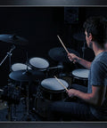 Man playing on an electronic drum kit with a focus on the 20x12 Kick Pad With Acoustic Wood Shell Single Zone Trigger Adjustable Tension