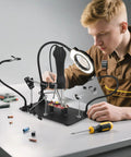 Person using Go-To Hands-Free Soldering Station With Upgraded 5x Magnifying Lamp, 360 Degree Clamp, Four PCB Holders, Extra Large Base