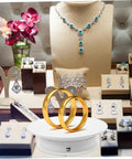 Autonomic Electric Rotating Display Stand For Jewelry Watches And Collectibles With Adjustable Speed showcasing gold rings in a shop display.