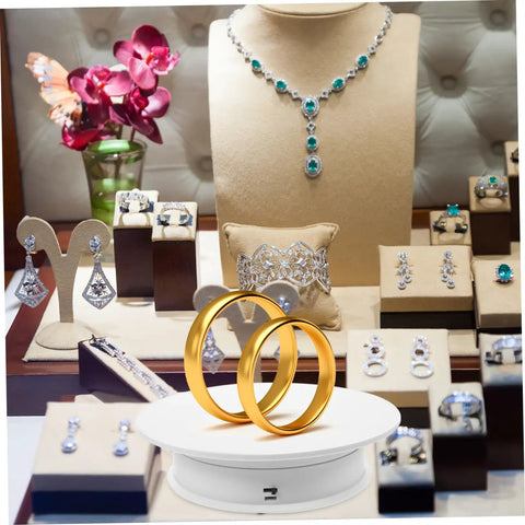 Autonomic Electric Rotating Display Stand For Jewelry Watches And Collectibles With Adjustable Speed showcasing gold rings in a shop display.