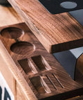 Close-up of wooden base with two round recesses and three shaped depressions, part of the dual tier coffee bean jar setup.