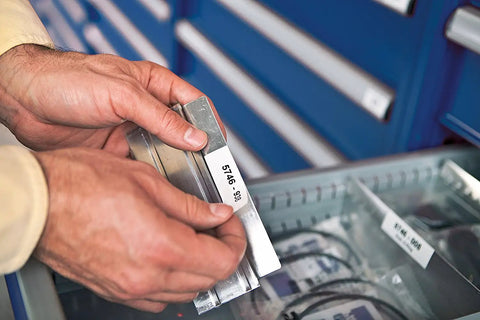 Man labeling metal parts with RhinoPRO 5200 Heavy Duty Label Maker With Carry Case For Job Sites Fast Printing On 3/4 Inch Vinyl Labels