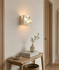 4.7" Mid Century Modern Wall Sconce, Minimalist Terrazzo Wall Light Fixture illuminating a wall beside a wooden table.