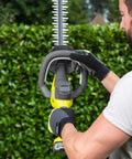 Pro Level 18V ONE PLUS Cordless Hedge Trimmer Featuring 55cm Double Edge Blades, ergonomic grip in use against greenery.