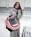 Woman holding All Season Waterproof Baby Car Seat Cover With 3D Mink Dot Interior in pink, shown in snowy outdoor setting.