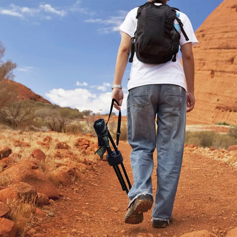 Person walking on a trail holding Portable Camping Swivel Folding Stool With 360 Degree Rotation Lightweight Tripod Chair
