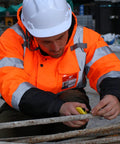 Construction worker wearing Hi Vis Reflective Bomber Jacket For Men Waterproof And Windproof Safety Coat with black bottom, class 3 certified.