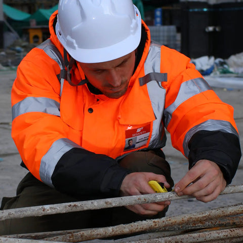 Construction worker wearing Hi Vis Reflective Bomber Jacket For Men Waterproof And Windproof Safety Coat with black bottom, class 3 certified.