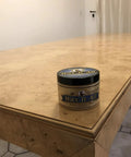 Real Deal Food Grade Beeswax Wood Polish And Cutting Board Wax, Nine Oz Jar on a polished wooden dining table.