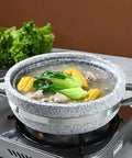 Heavy Duty Thick Granite Stone Bowl With Wood Base And Glass Lid Induction Ready Donabe Style Pot For Bibimbap Rice Bowls No Fuss Hearty Soups Stews And Slow Cooks 30 Cm in use on stove