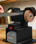 Premium Cordless Mini Bench Grinder And Polisher Featuring A Kickass 200W Motor Cranking At 7000 Rpm Paired With Dual 4000 mAh Batteries in use during knife sharpening.