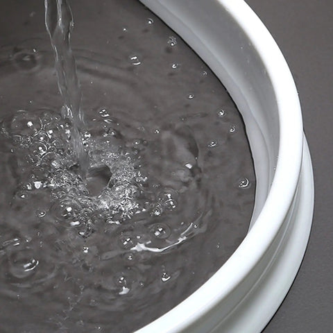 Water flowing over the 67 Inch Collapsible Shower Threshold Water Dam Barrier For Dry And Wet Separation In Bathroom And Kitchen