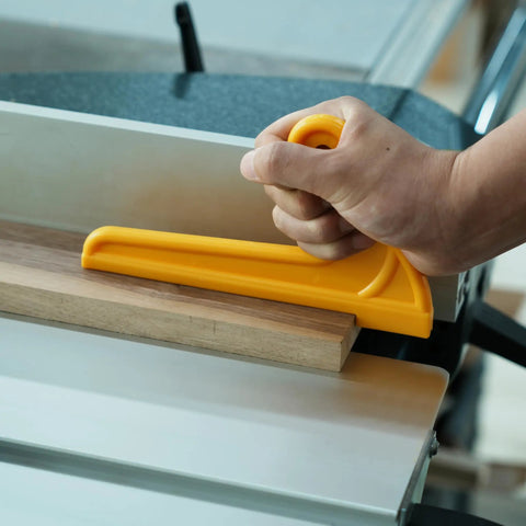 Hand using yellow push stick for table saw, ensuring safety while cutting wood. Heavy Duty Push Block And Push Stick Set For Table Saws Router Tables Band Saws Delivers Smooth Handling And Slays Kickback Dead In Its Tracks On Every Cut.