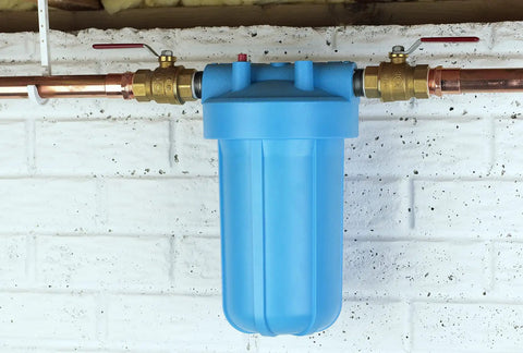 OmniFilter BF7 10 Inch Whole House Water Filtration System with Big Blue Housing installed on wall with copper piping