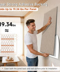 Man installing oversized self adhesive acoustic wall panel made from dense polyester fiber for quiet room treatment.