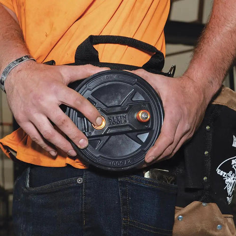 Person holding a Tie Wire Reel With Quick Lock And Lightweight Aluminum Body, Ambidextrous Rewind Knob, durable pro grade tool accessory.