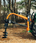 9 Inch Auger Bit For 3 Point Post Hole Digger With Fishtail Point HD Steel Digging Bit Only 24 Inch Drilling Depth Bolt On Safety Cover Compatible With 30HP And 60HP Units attached to tractor in a forest setting.
