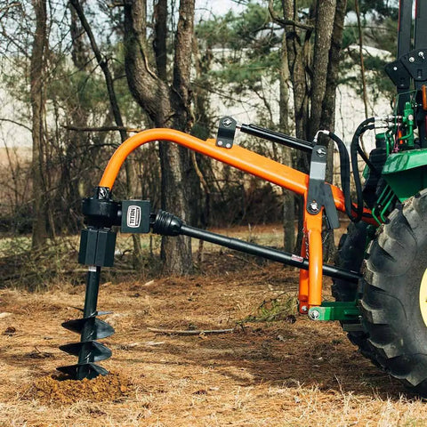 9 Inch Auger Bit For 3 Point Post Hole Digger With Fishtail Point HD Steel Digging Bit Only 24 Inch Drilling Depth Bolt On Safety Cover Compatible With 30HP And 60HP Units attached to tractor in a forest setting.