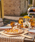 Heavy Duty 14 Inch Bamboo Pizza Peel And Wooden Spatula Paddle For Backyard Cookouts with pizza on a rustic table.