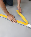 Person applying moisture shield tape on Premium Underlayment For Luxury Vinyl Laminate And Hardwood Floors Beat The Noise Sound Pad.